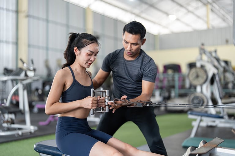 Fitness trainer helping woman with cable exercises